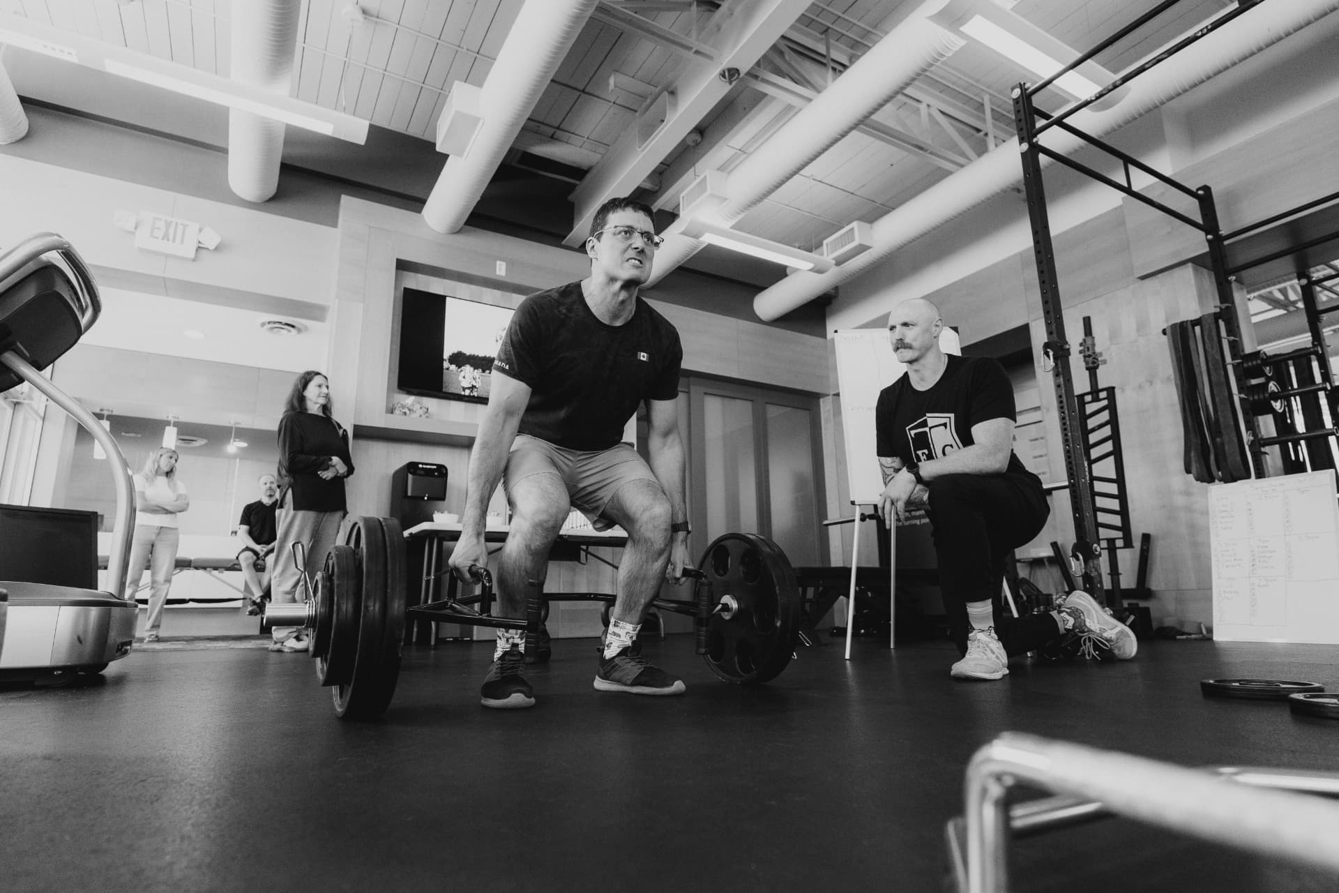 Athlete performing a trap-bar deadlift with Liam coaching
