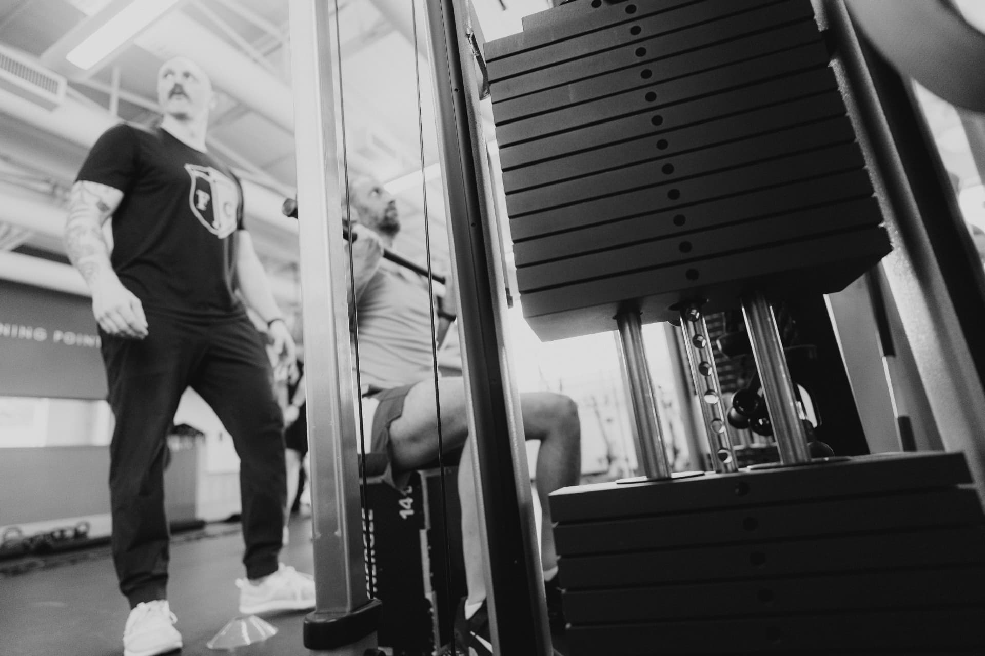 Coach cueing a client on a cable machine